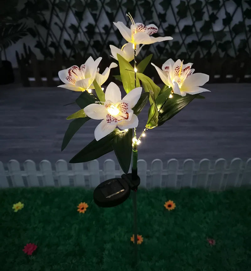 Decorative solar light with white flowers on a grassy area