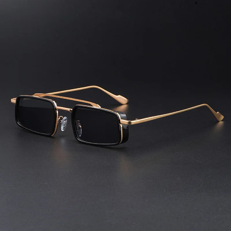 Gold-framed sunglasses with black lenses on a dark background
