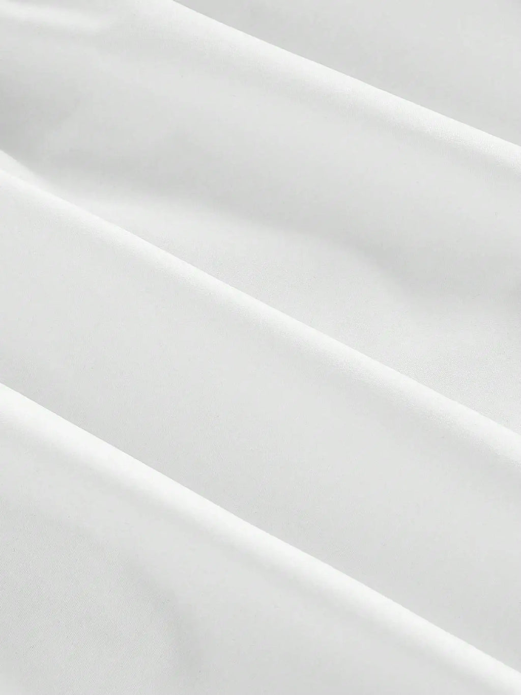 A close-up of draped white fabric with soft folds and a smooth texture.
