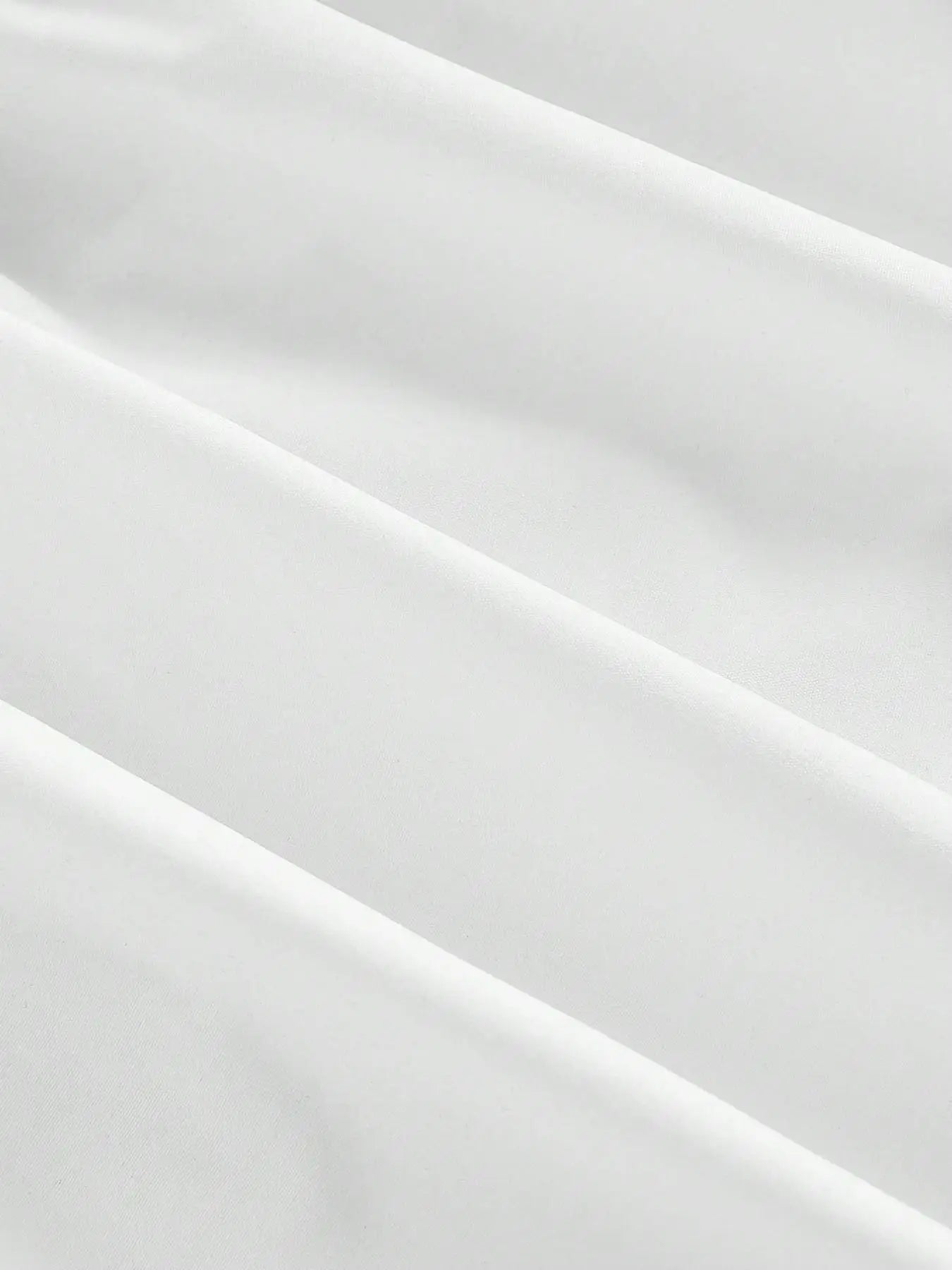 A close-up of draped white fabric with soft folds and a smooth texture.